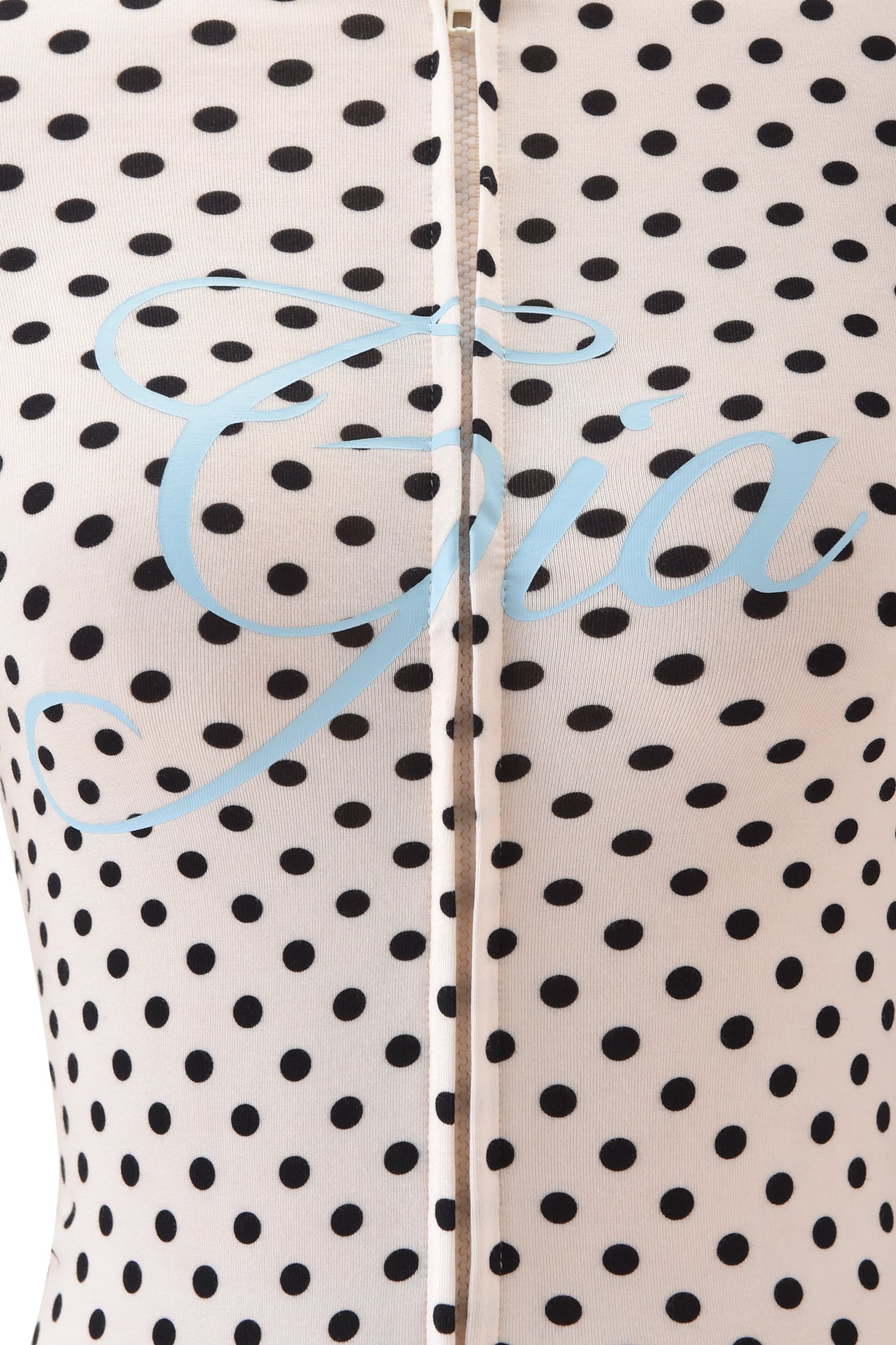 Close-up of the I.AM.GIA BLARE HOODIE in cream polka dot fabric, featuring the light blue Gia logo script across the chest and a vertical center zipper.
