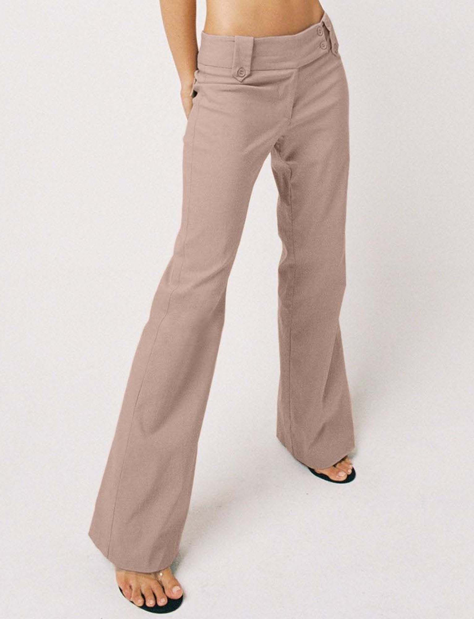 Someone stands against a white background wearing TIGERMIST’s KITTIE PANT - TAUPE, featuring a high-waisted, flared leg fit. The pants are paired with black open-toe sandals; the upper body is mostly out of frame.