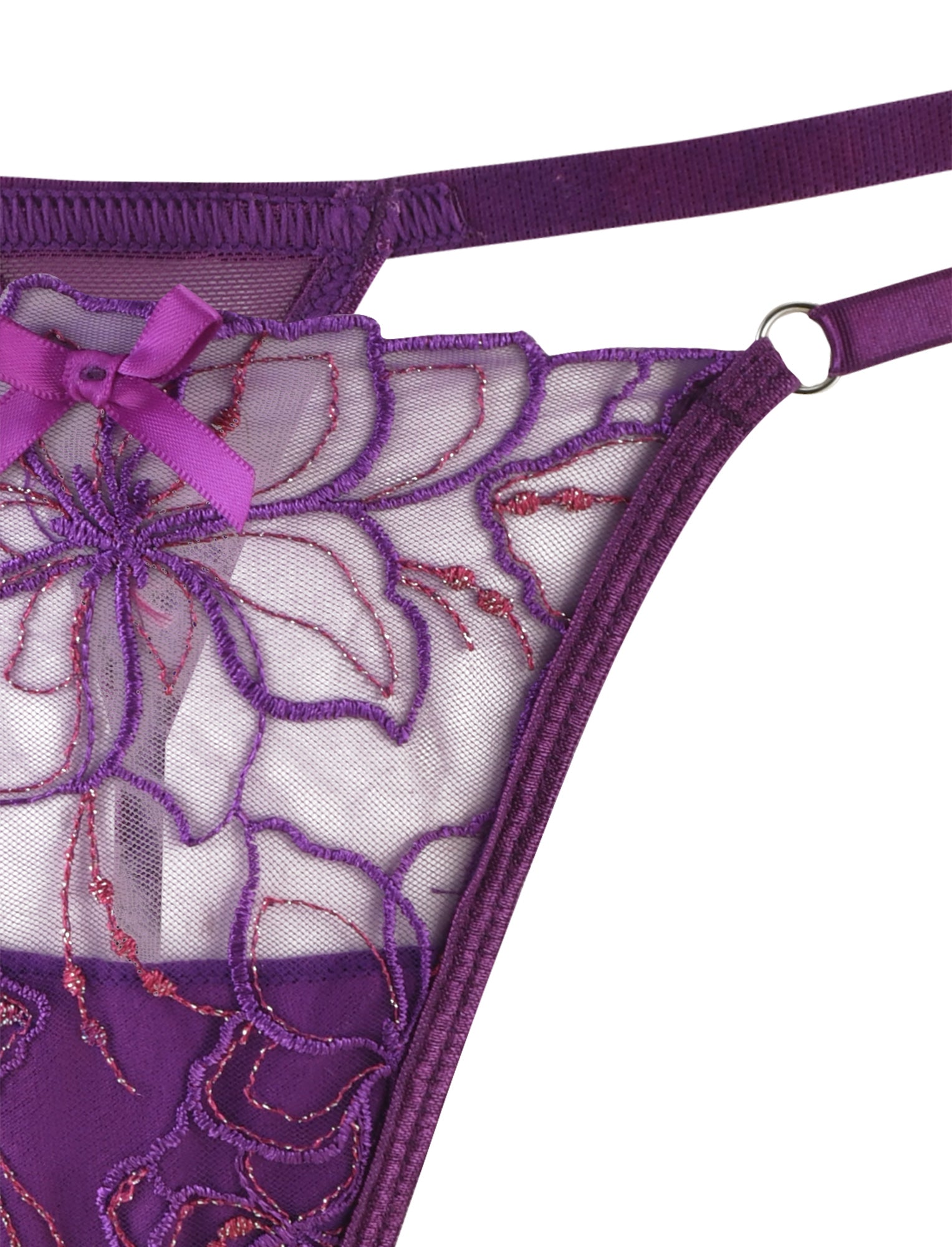 Close-up of the LAURA SET - PURPLE : LAVENDER by TIGERMIST, featuring a delicate purple lace intimate set adorned with floral lurex embroidery. The set includes a charming decorative bow at the waist and adjustable shoulder straps. The sheer fabric beautifully showcases the intricate thread details within the floral pattern.