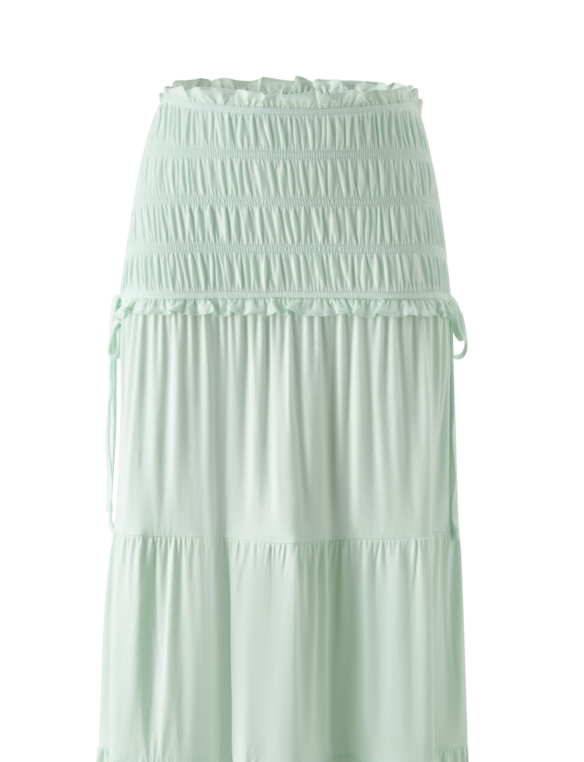 The DENALI MAXI SKIRT in Soft Mint by TIGERMIST features a shirred elastic waistband, tiered flowy design, soft modal fabric for a relaxed fit, and decorative side ties.