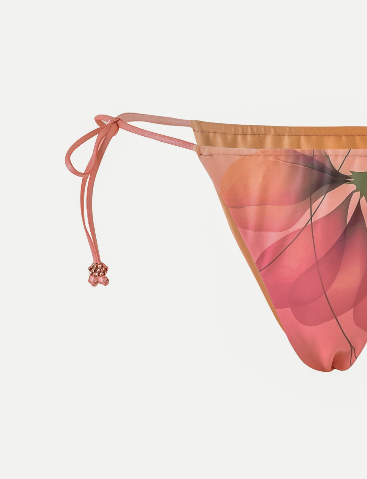 A close-up image of the AVE Bikini Bottom - Multi with a Macro Floral and Gradient Floral design from TIGERMIST. The pink bikini bottom features side ties adorned with decorative pink beads against a white background.