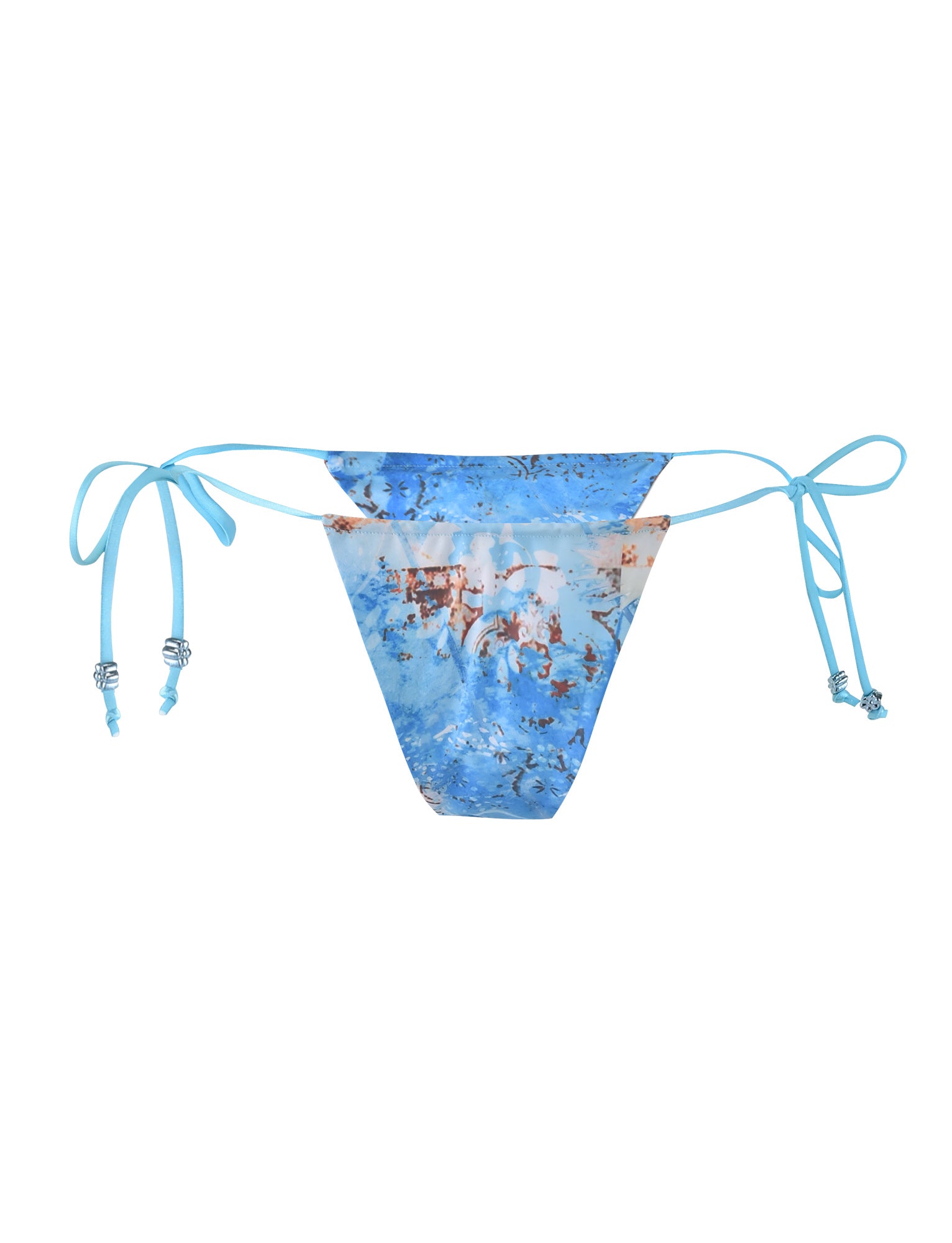 A close-up view of the AVE BIKINI BOTTOM - BLUE : TILE, designed by TIGERMIST. The bikini bottom features adjustable string ties on the sides adorned with small decorative beads, and showcases a mix of blue, white, and brown colors in a watercolor-like floral pattern.