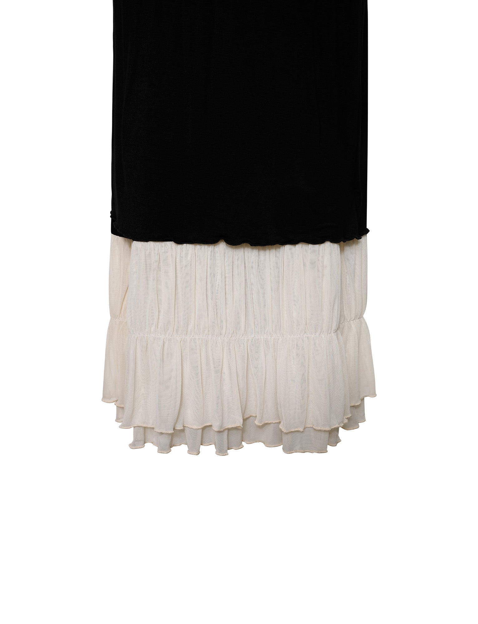 The KACIE DRESS - BLACK from TIGERMIST is a two-tone maxi skirt with a black upper section and a white, ruffled lower section. The layered white fabric extends below the black, creating an eye-catching contrast. The skirt has a straight silhouette with no visible patterns or embellishments.