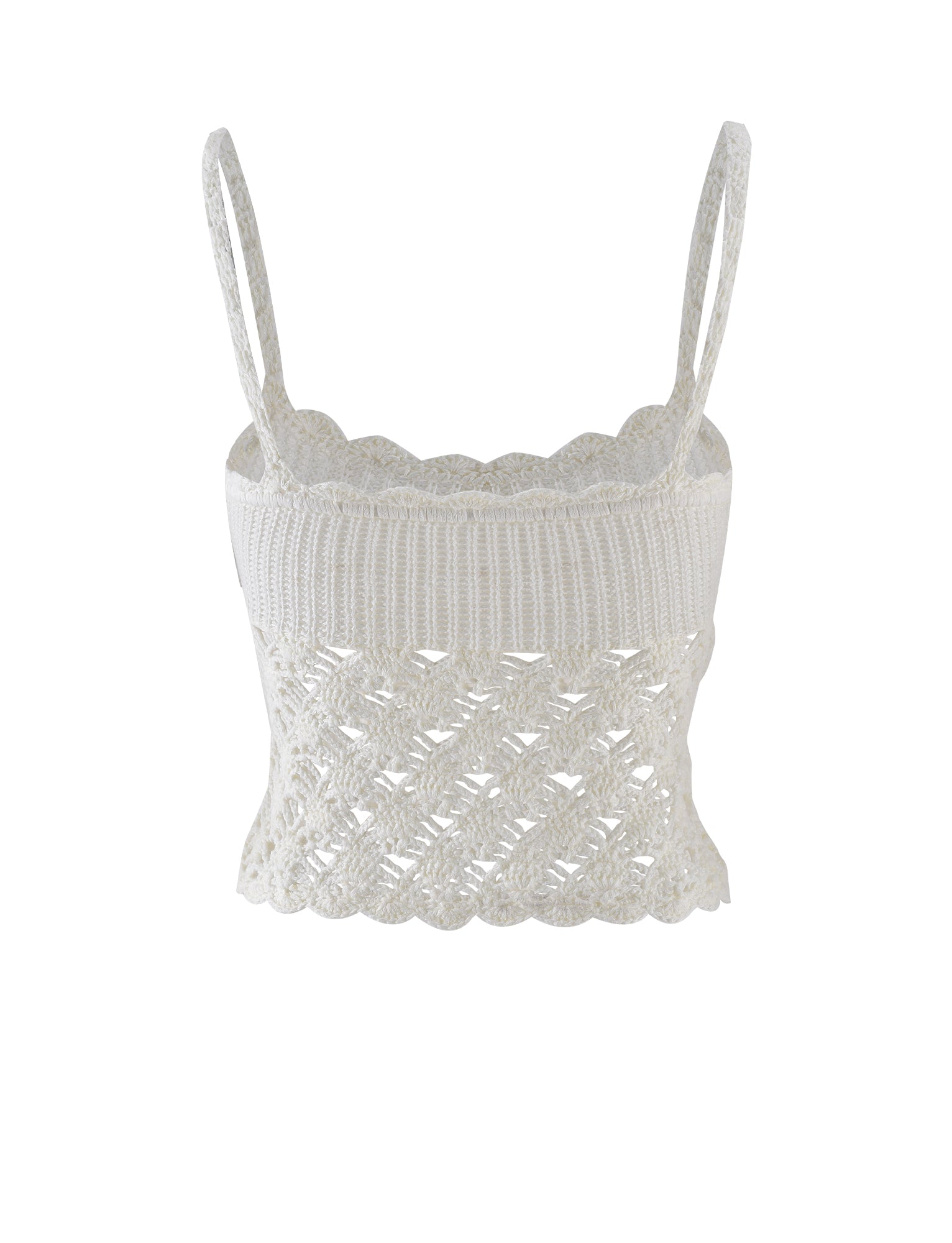 The RIKI TOP in white from TIGERMIST is a feminine, lightweight knitted crop top with delicate shoulder straps. It features intricate lace detailing and a scalloped hemline, combining a snug, ribbed upper section with an open and airy knit pattern below.