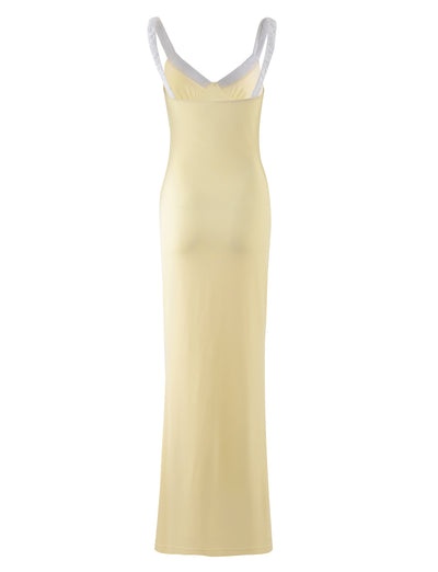 A long, sleeveless AMARAN DRESS - YELLOW : LEMON by TIGERMIST, featuring a fitted silhouette with white crisscrossing shoulder straps and a deep neckline.