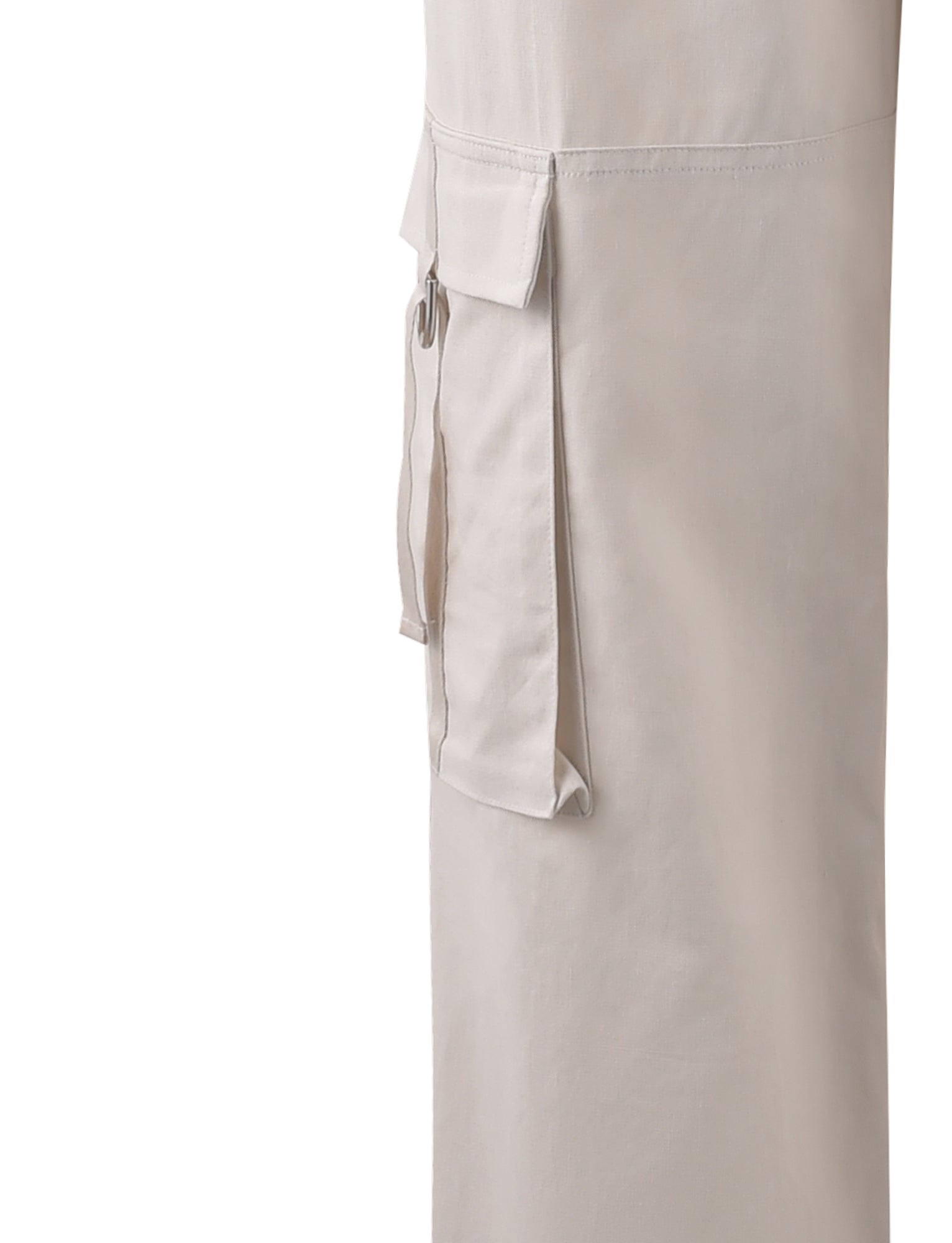 Close-up of a cream fabric cargo pocket with flap and button detail on the side of a TIGERMIST KAYA PANT - WHITE : CREAM garment. The material appears to be lightweight and slightly textured. The image focuses on the pocket, with no other visible parts of the garment or background.