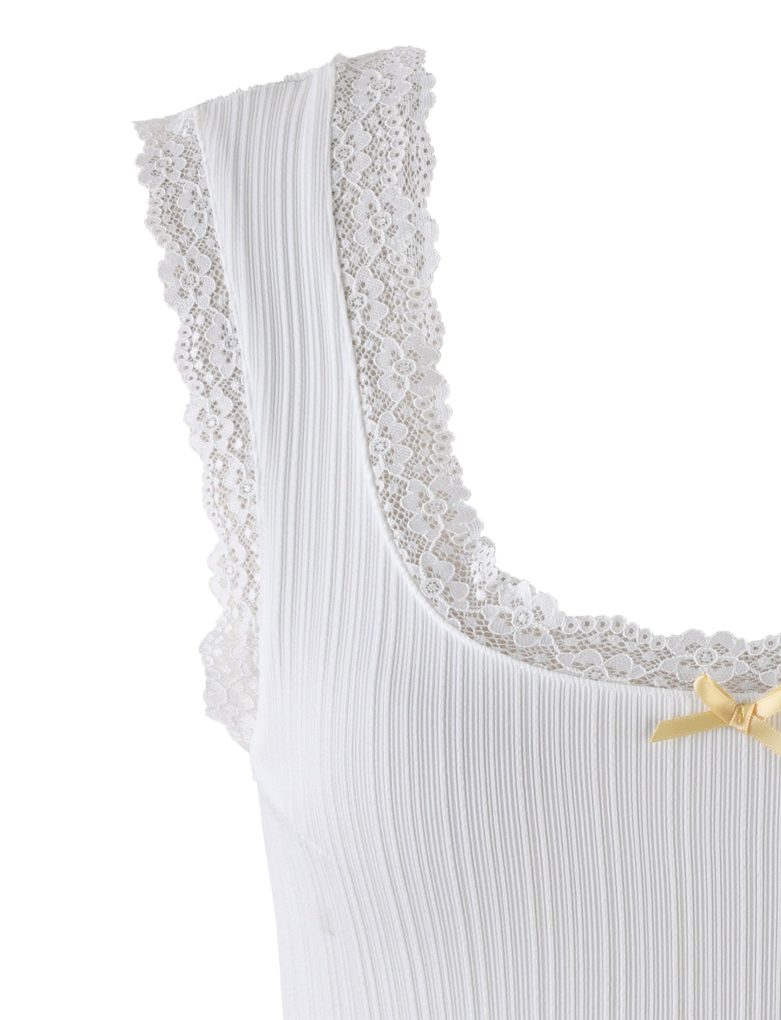 A detailed close-up of the SABINE TOP - WHITE from TIGERMIST showcases its delicate lace trim along the neckline and shoulder straps. The ribbed fabric is elegantly highlighted by a small, decorative yellow bow on the front, emphasizing the intricate details of this stylish piece.