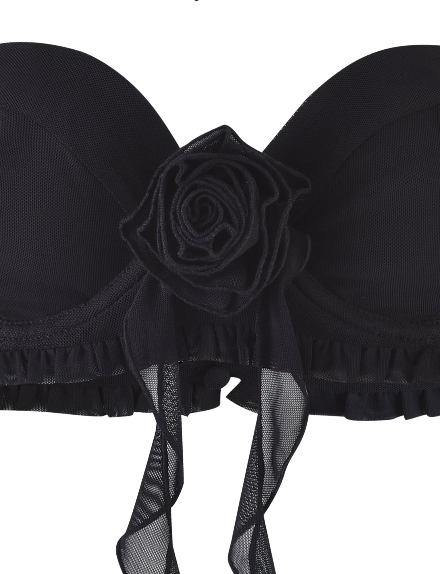 The HEAVEN TOP - BLACK from TIGERMIST is a strapless black bra adorned with a large fabric rose and flowing ribbon detail at the center. Its design showcases mesh-like fabric with ruffled trim along the bottom edge, all set against a plain white background.