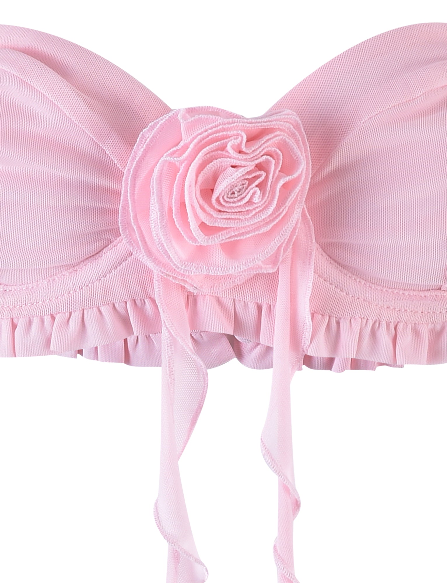 Close-up of the HEAVEN TOP - PINK by TIGERMIST, showcasing a decorative fabric rose at the center. This bandeau top is detailed with ruched fabric and a frilled trim along the bottom, complemented by ribbon-like straps that hang down from the flower.