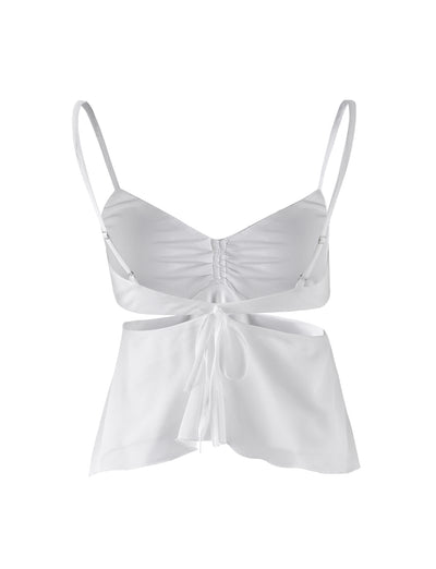 The RIOT TOP - WHITE by TIGERMIST is a sleeveless crop top with thin shoulder straps and a front tie. This top features ruched detailing at the bust and a slight flare at the hem, creating a flowy appearance.