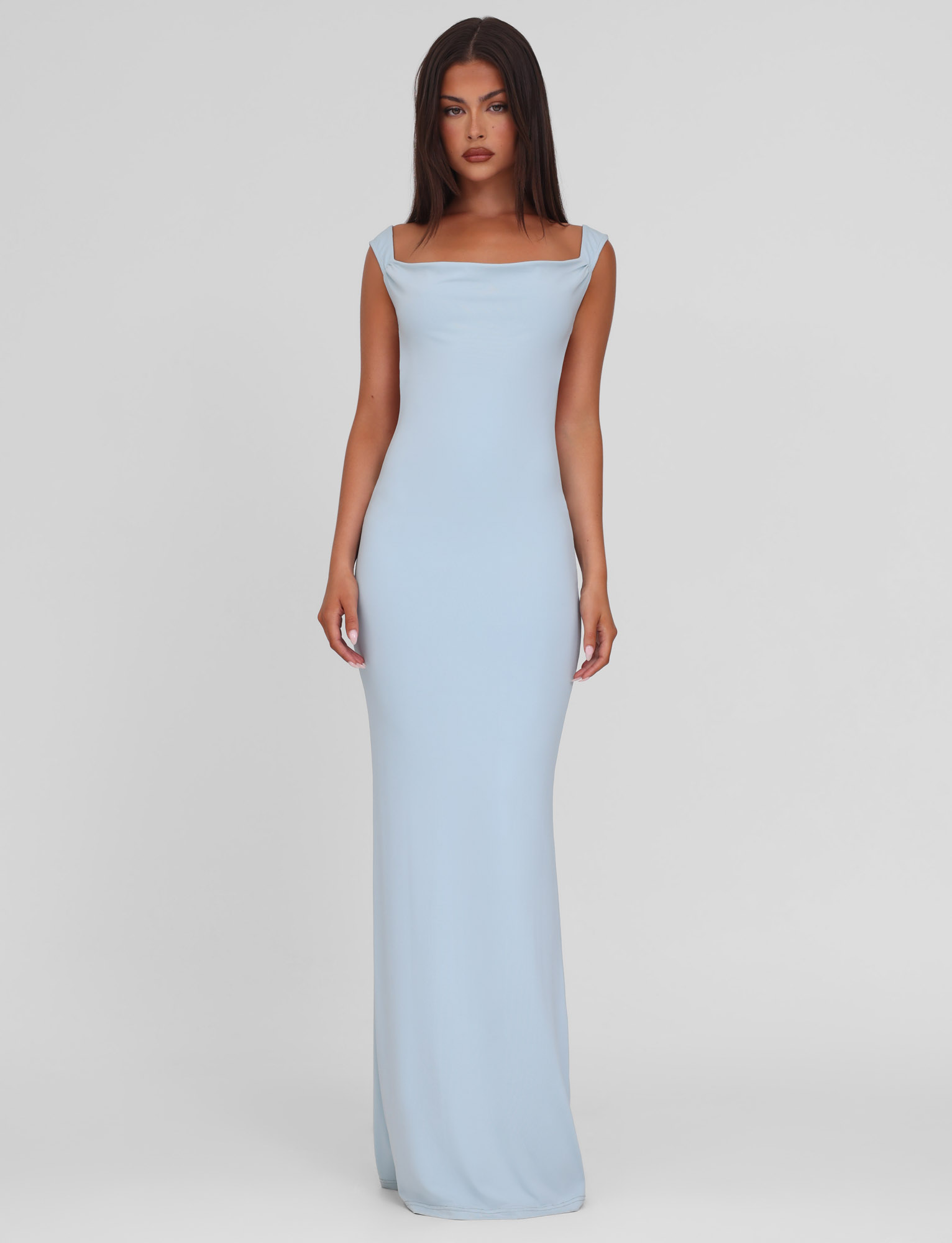 A woman with long brown hair faces forward in the TIGERMIST ZITA DRESS - BLUE : BABY BLUE, a sleeveless maxi dress with a square neckline, against a plain white background.