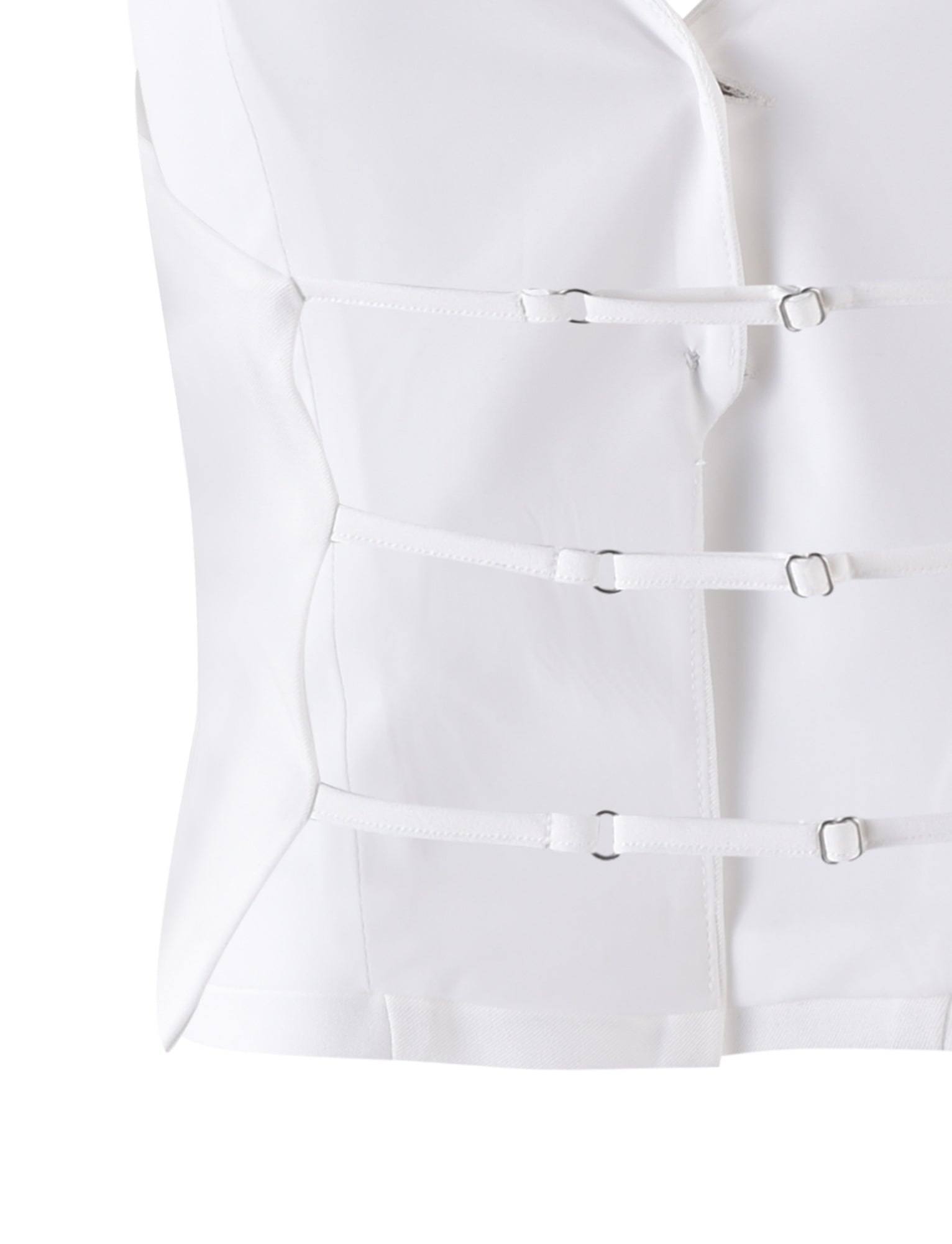 The JAYLIN VEST - WHITE by TIGERMIST is a white garment resembling a straitjacket, featuring multiple horizontal straps and buckles across the front and primarily composed of smooth fabric. The close-up image focuses on the midsection, highlighting the fastenings and overall design.