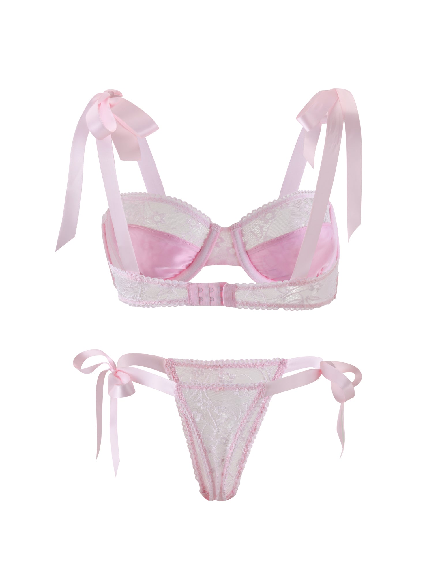 The SUGAR SET - PINK : PASTEL PINK from TIGERMIST is a delicate lingerie ensemble featuring a light pink lace bra with ribbon straps tied into bows at the shoulders, and a matching lace thong with side ribbon ties. The bra is designed with scalloped edges and has a hook-and-eye closure at the back.