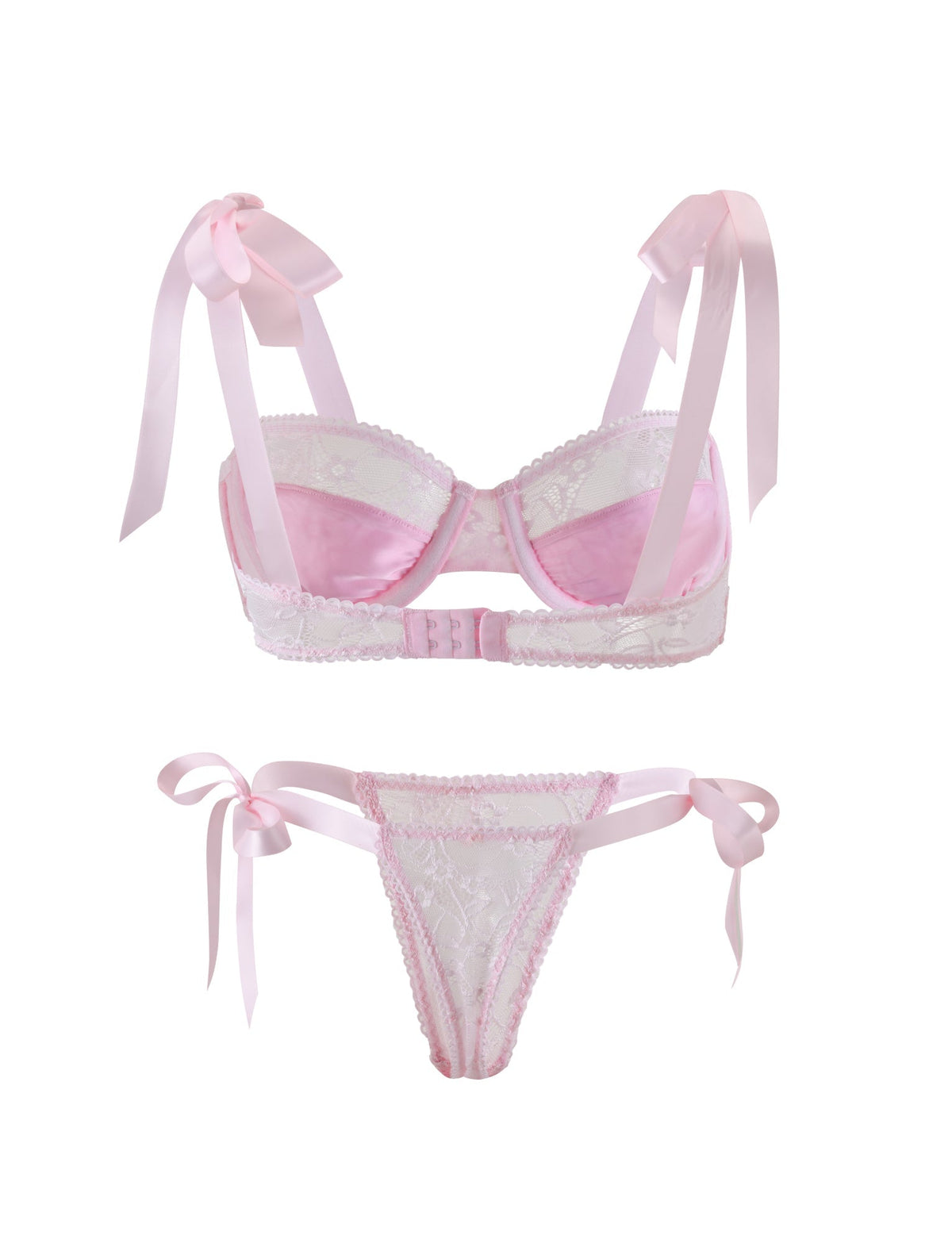 The SUGAR SET - PINK : PASTEL PINK from TIGERMIST is a delicate lingerie ensemble featuring a light pink lace bra with ribbon straps tied into bows at the shoulders, and a matching lace thong with side ribbon ties. The bra is designed with scalloped edges and has a hook-and-eye closure at the back.
