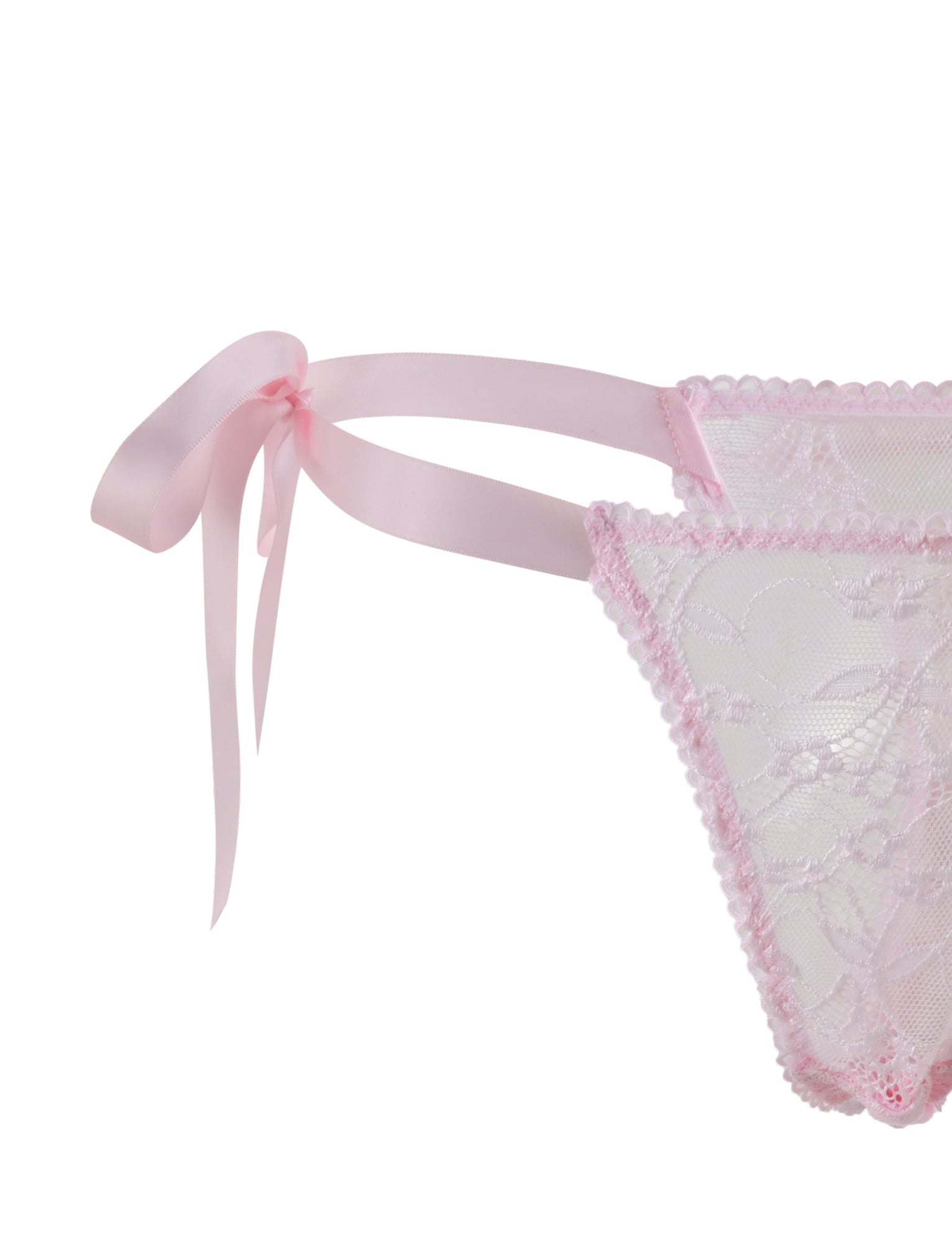 The SUGAR SET - PINK : PASTEL PINK by TIGERMIST features delicate pink lace lingerie with ribbon ties on the side. The fabric is adorned with floral lace patterns and has scalloped edges. A prominently tied bow adds a feminine and romantic touch, all set against a white background.