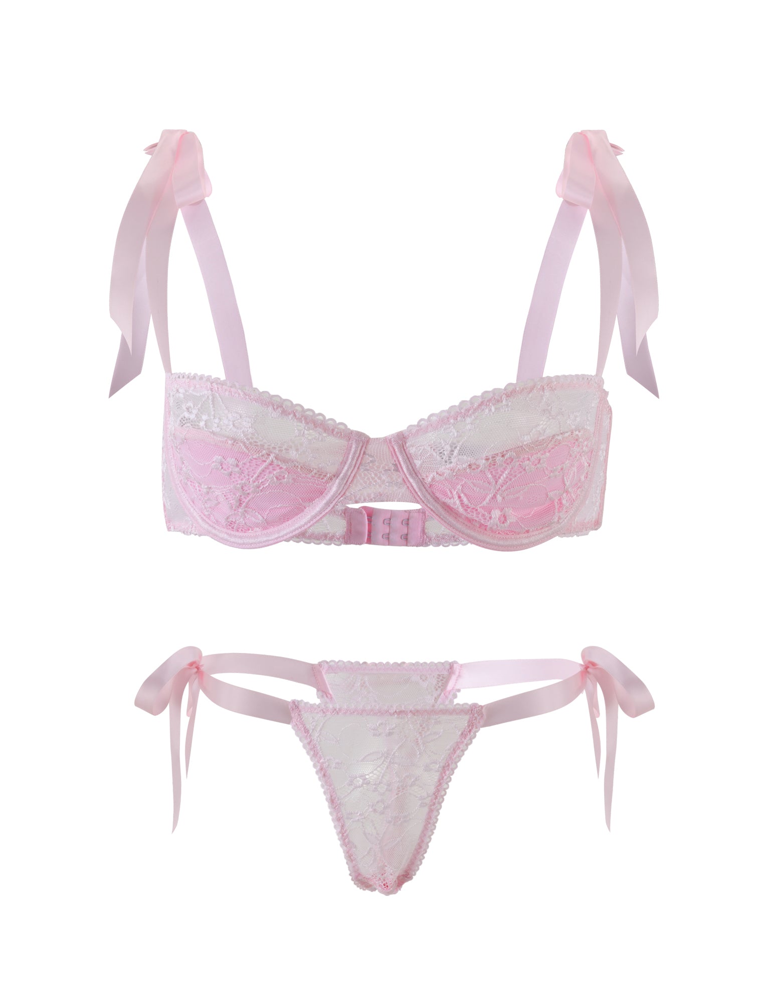 The SUGAR SET - PINK from TIGERMIST is a stunning pastel pink and white lace lingerie set. The bra showcases charming pink straps adorned with bows on the shoulders, complemented by intricate lace detailing on the cups. The matching panties feature delicate pink side ties and mirror the lace design in the front, giving both pieces a delicate, feminine appearance.