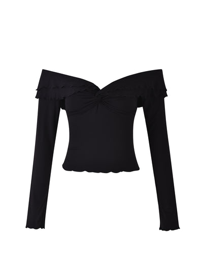 Introducing the DENALI LONG SLEEVE TOP - BLACK from TIGERMIST. This elegant black off-the-shoulder top features long sleeves, a twisted knot detail in the center of the neckline, and ruffled trim along both the off-the-shoulder line and cuffs. The hemline and cuffs are subtly scalloped, adding to its sophisticated charm.
