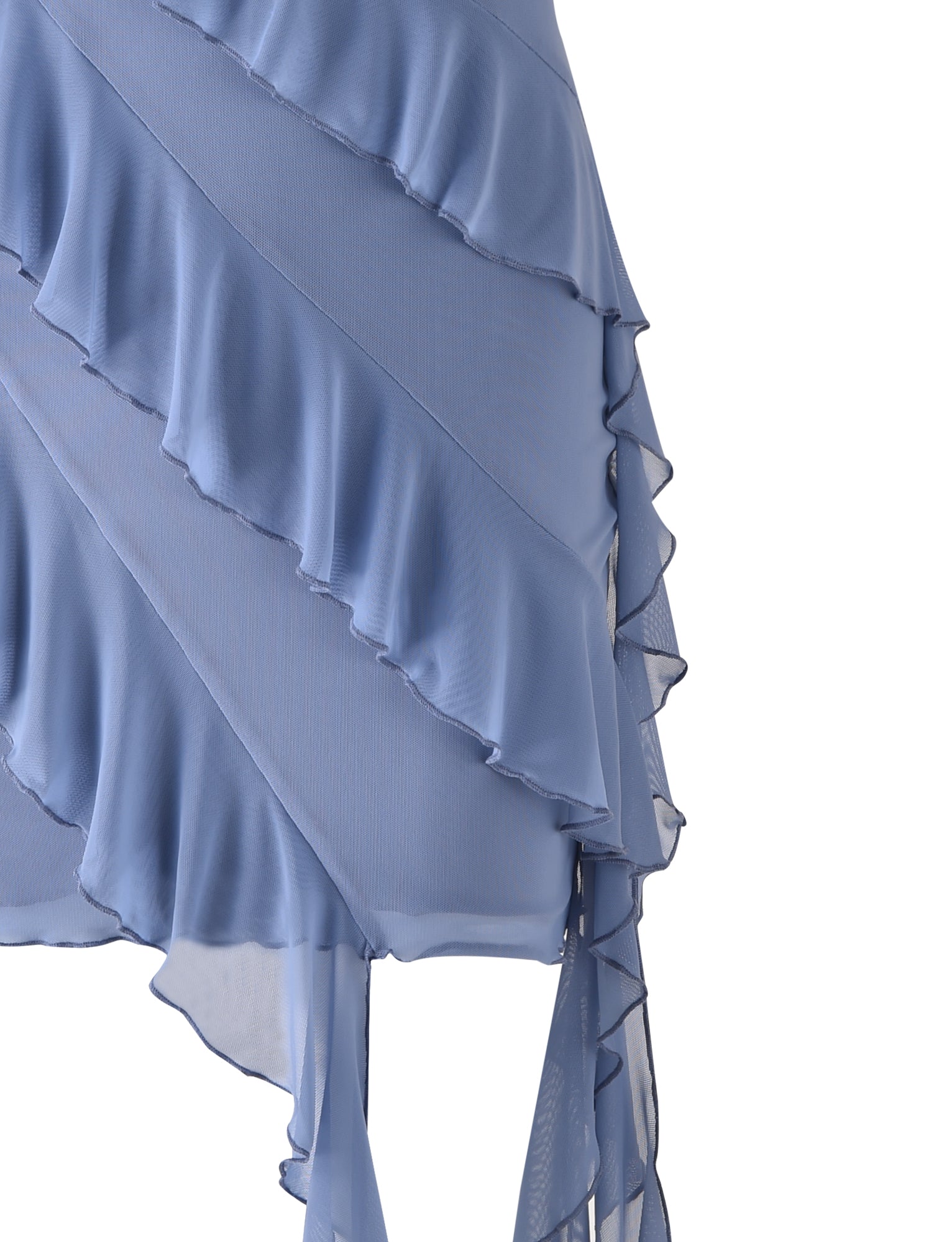 Close-up of the TIGERMIST SADIA DRESS - BLUE : DUSTY BLUE, showcasing its light blue, ruffled, asymmetrical fabric with multiple layers. The material is lightweight and sheer, creating a delicate and flowy appearance. The ruffles are arranged diagonally, adding both texture and elegance to the dress.