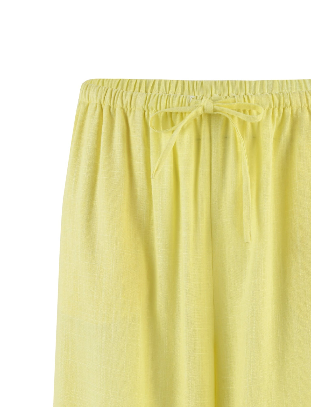 Close-up of light yellow LAINEY PANT - YELLOW : LEMON by TIGERMIST, featuring an elastic waistband and a drawstring tie. The lightweight, slightly textured fabric makes it suitable for casual or loungewear.