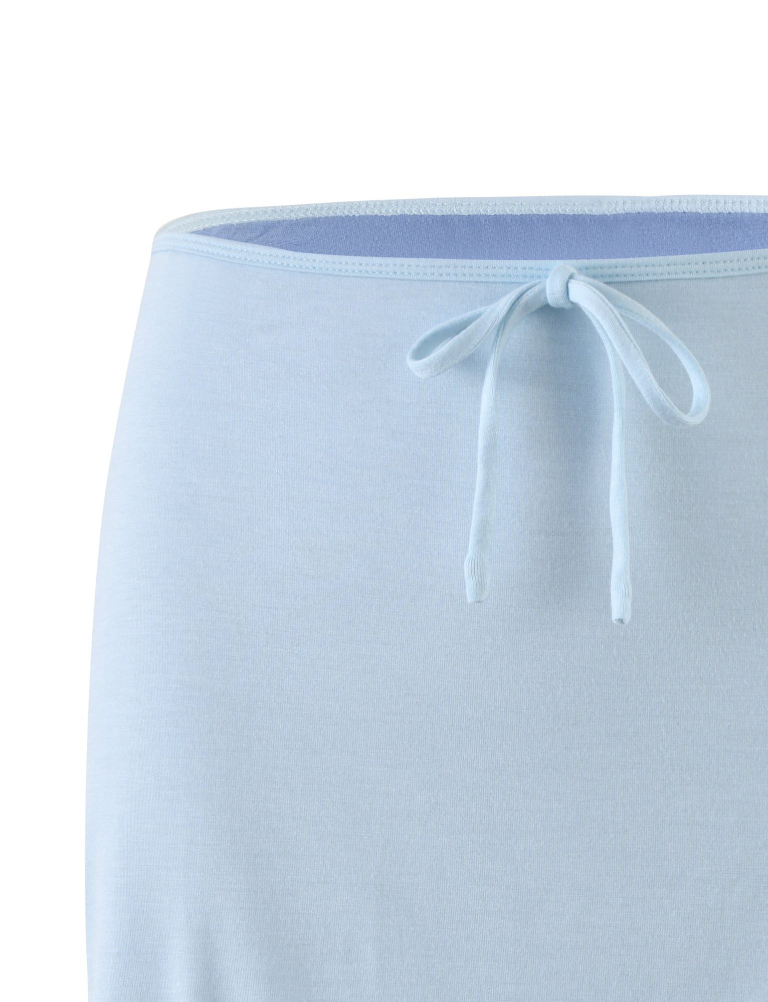 Close-up of the ADAIR SKIRT - BLUE from TIGERMIST, showcasing its light blue color and elastic waist with a drawstring tied in a neat bow at the front. The skirt is made of soft fabric and features a stitched hem along the top.