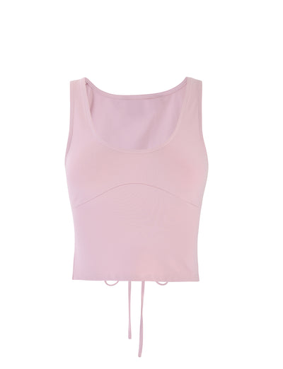 The LERO TOP in Baby Pink from TIGERMIST is a light pink, sleeveless crop top with a scoop neckline and an adjustable drawstring at the hem.