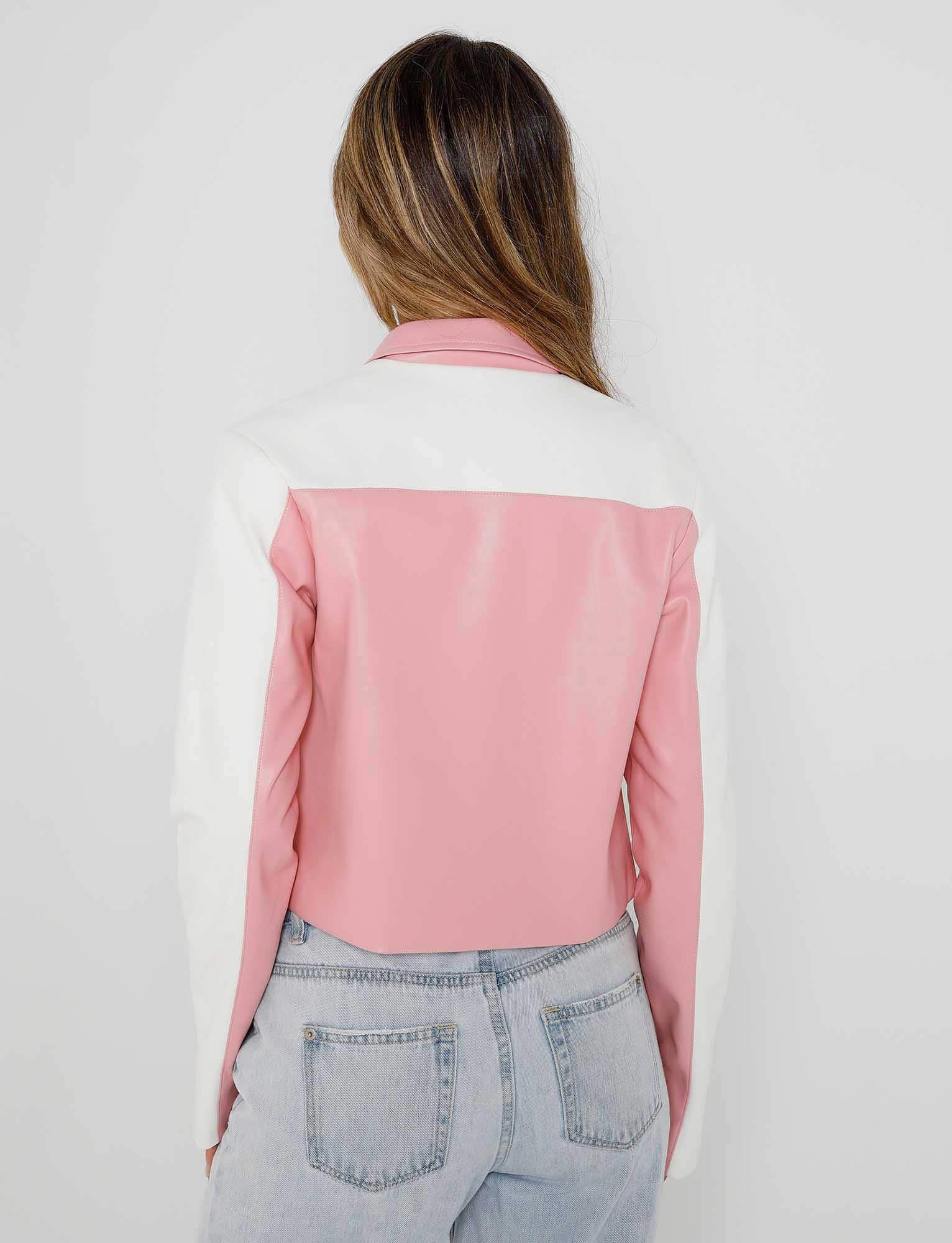 A person with long hair is standing with their back to the camera, showcasing a trendy DELIA JACKET - PINK in pink and white from TIGERMIST, paired with light blue denim jeans. The background is plain white.