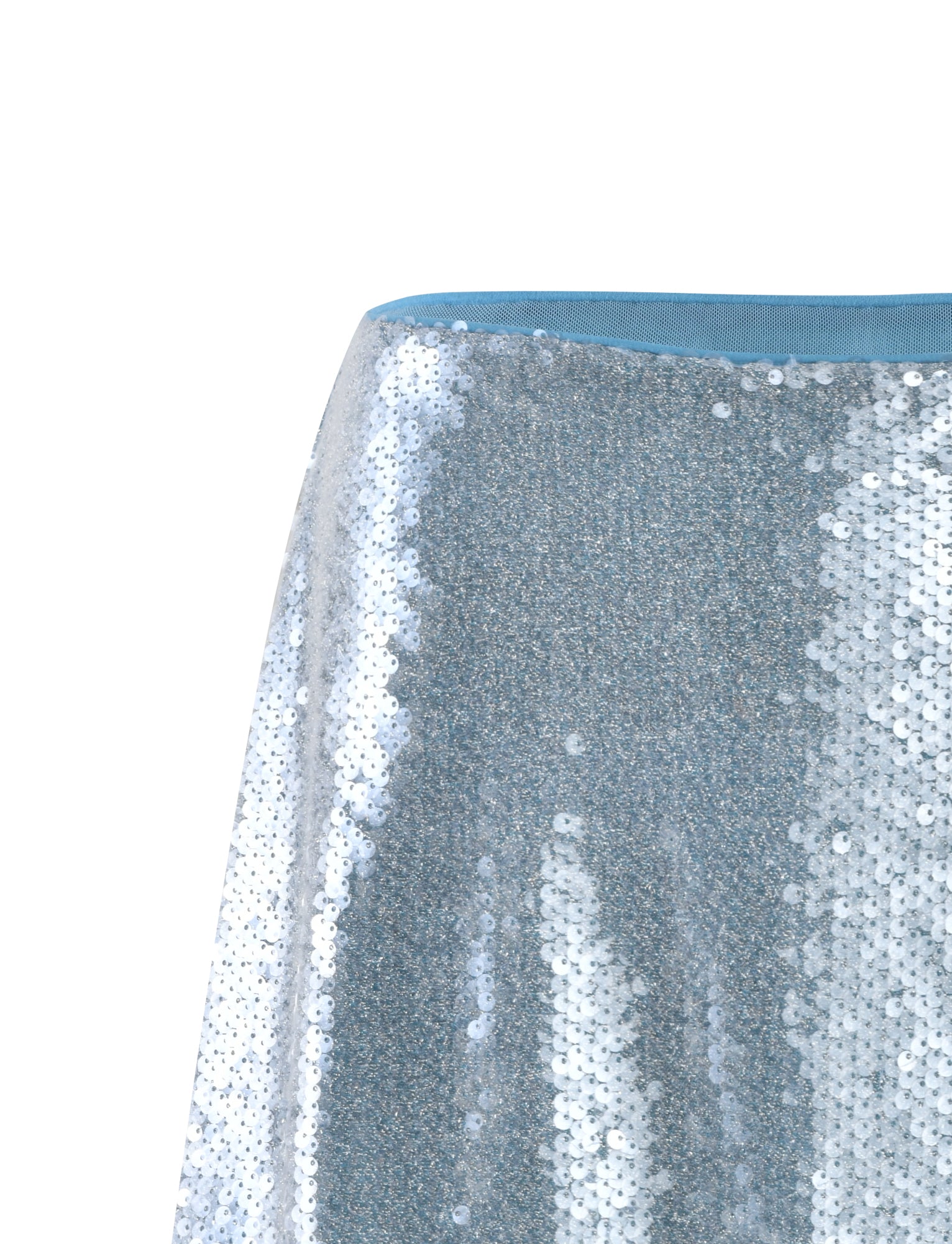 A close-up of the ILYANA SKIRT - BLUE from TIGERMIST shows a shimmering sequin skirt with a light blue elastic waistband. The sequins create a sparkling effect with various shades of silver and light, reflecting off the surface. The background is plain white.