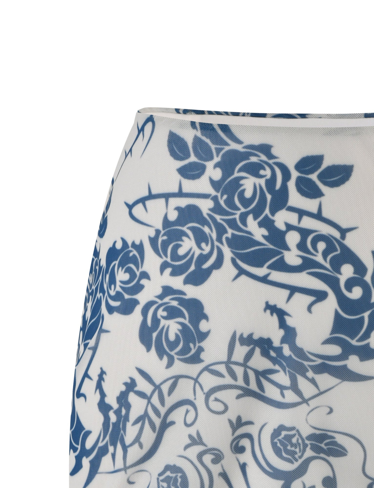 A close-up of the FINOLA MESH MINI SKIRT from TIGERMIST reveals an intricate blue floral and vine pattern on a white background. The detailed tattoo print features various flowers and leaves with swirling vines, creating an elaborate and decorative appearance.