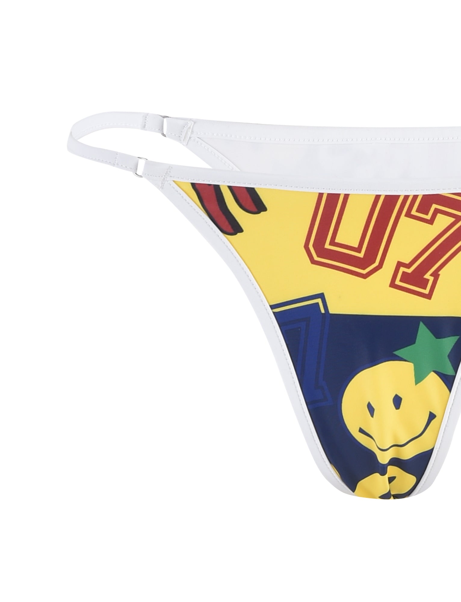 Close-up of a colorful Diana Bikini Bottom - Multi: Collage: Graphic Print by Tigermist, featuring partial views of bold numbers "07" in red and yellow, a smiling face with a green star on the forehead, and assorted graphics on a yellow and blue background. White adjustable straps are also visible.