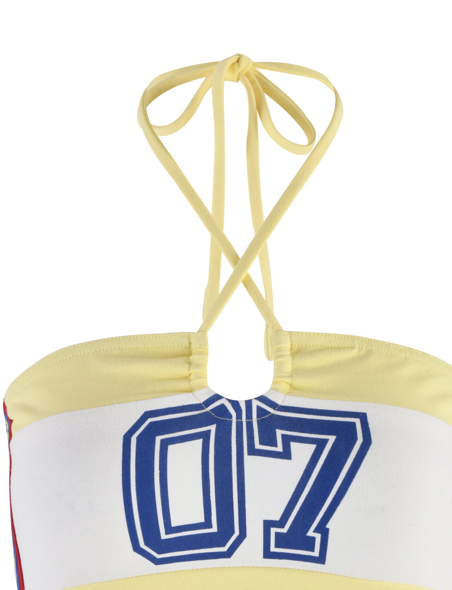 Close-up of the KAIN TOP - YELLOW : LEMON by TIGERMIST. This yellow halter top features a back tie and displays the number "07" in bold, blue outlined white digits on the front. The ribbed fabric is smooth, and the neckline is slightly gathered at the front.