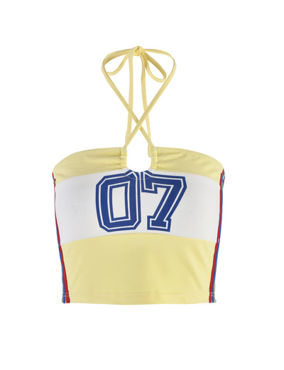 A TIGERMIST KAIN TOP - YELLOW : LEMON halter-neck crop top features a white horizontal band across the chest with a large blue "07" design. It has thin ties for securing around the neck and rainbow stripes running vertically along the side seams.