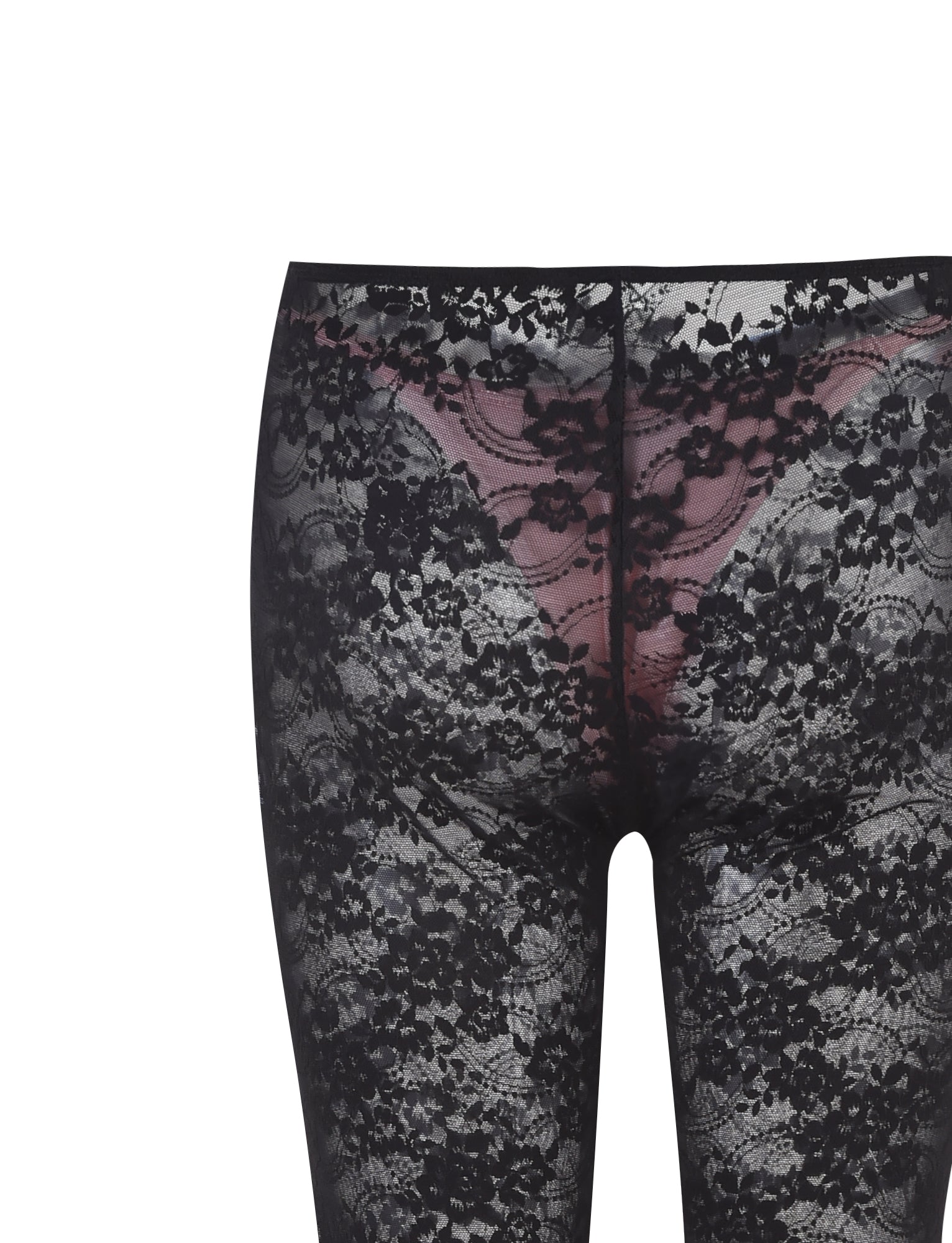A close-up view of a person wearing the TIGERMIST MELANIE PANT in black lace, featuring a see-through floral pattern. The leggings reveal a pair of pink underwear beneath. The background is plain white.