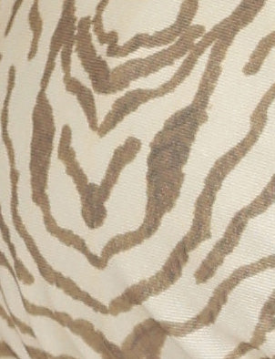 A close-up of the FINLEA BIKINI BOTTOM from TIGERMIST showcases a beige and cream zebra stripe pattern. The design features irregular stripes that mimic the natural patterns found on a zebra's coat. Crafted from high stretch fabric, the texture appears smooth, while the soft, neutral colors exude an understated elegance.