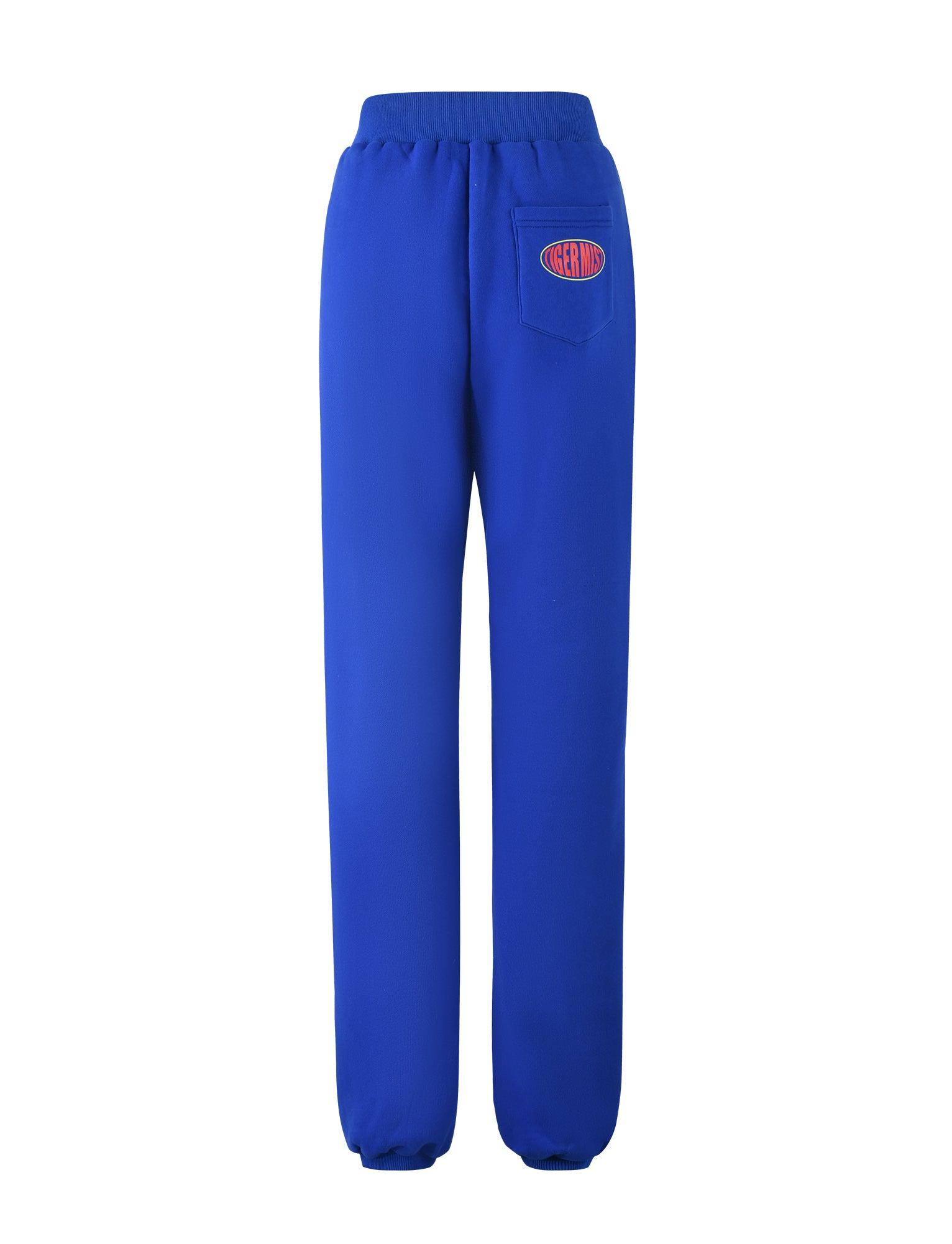 A view from the back of the LUMEN PANT - BLUE by TIGERMIST reveals a pair of bright blue sweatpants with a single rear pocket on the right side. The pocket is adorned with a red and blue logo featuring the text "Oregon." These sweatpants also come equipped with an elastic waistband and ankle cuffs.