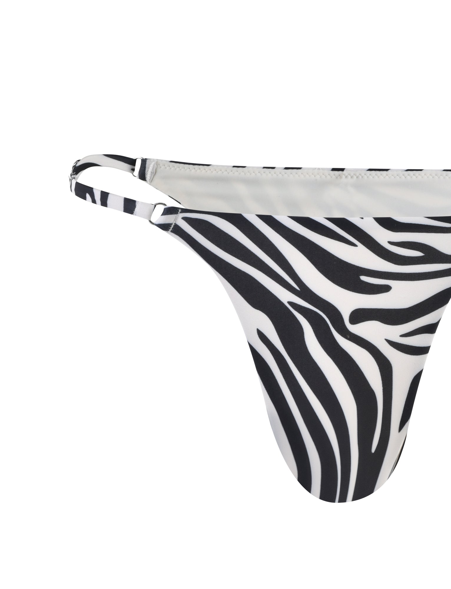 Close-up view of the right side of the TIGERMIST DIVINA BIKINI BOTTOM - BLACK : ZEBRA, showcasing its eye-catching zebra print pattern. The predominantly white fabric with wavy black stripes is highlighted by a thin strap on the right edge, set against a plain white background.