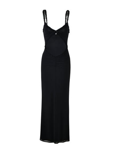 A sleeveless, floor-length dress called the RAYLA DRESS - BLACK from TIGERMIST, featuring a body-hugging silhouette. This elegant dress has intricate cut-out details at the midsection and delicate lace embellishments on the shoulder straps and cut-out areas. The fabric is smooth and slightly stretchy.