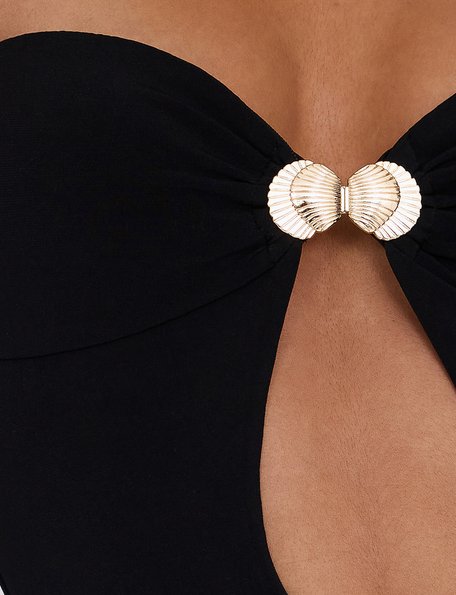 Close-up of TIGERMIST's CECILY MAXI DRESS in black, a strapless maxi dress with a front cut-out and gold seashell clasp. The sweetheart neckline beautifully accentuates your skin tone.