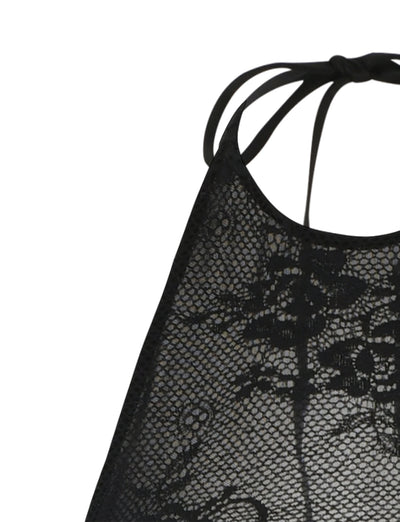 Close-up of the LUCIA DRESS - BLACK : LACE from TIGERMIST, featuring intricate floral patterns. The fabric appears delicate and elegant, with thin straps visible at the top of the image, suggesting it may be a piece of lingerie or a decorative top.