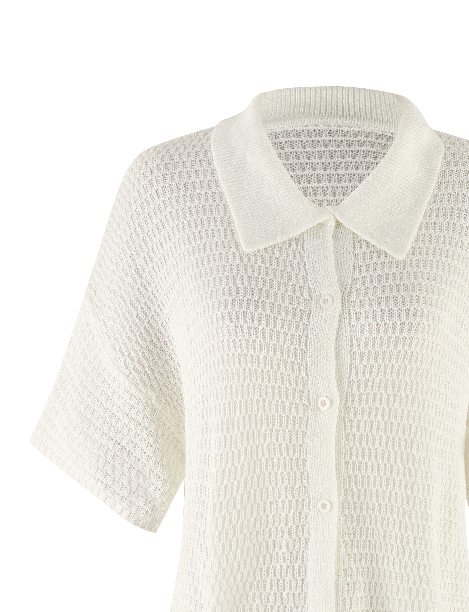 A close-up view of the JANAI TOP - WHITE : CREAM by TIGERMIST, showcasing its light cream-colored, short-sleeve, button-up knit design with a textured pattern and flat collar. Resembling a delicate white crochet top, the small buttons match the color of the cardigan. The image focuses on the upper half of this elegant garment.