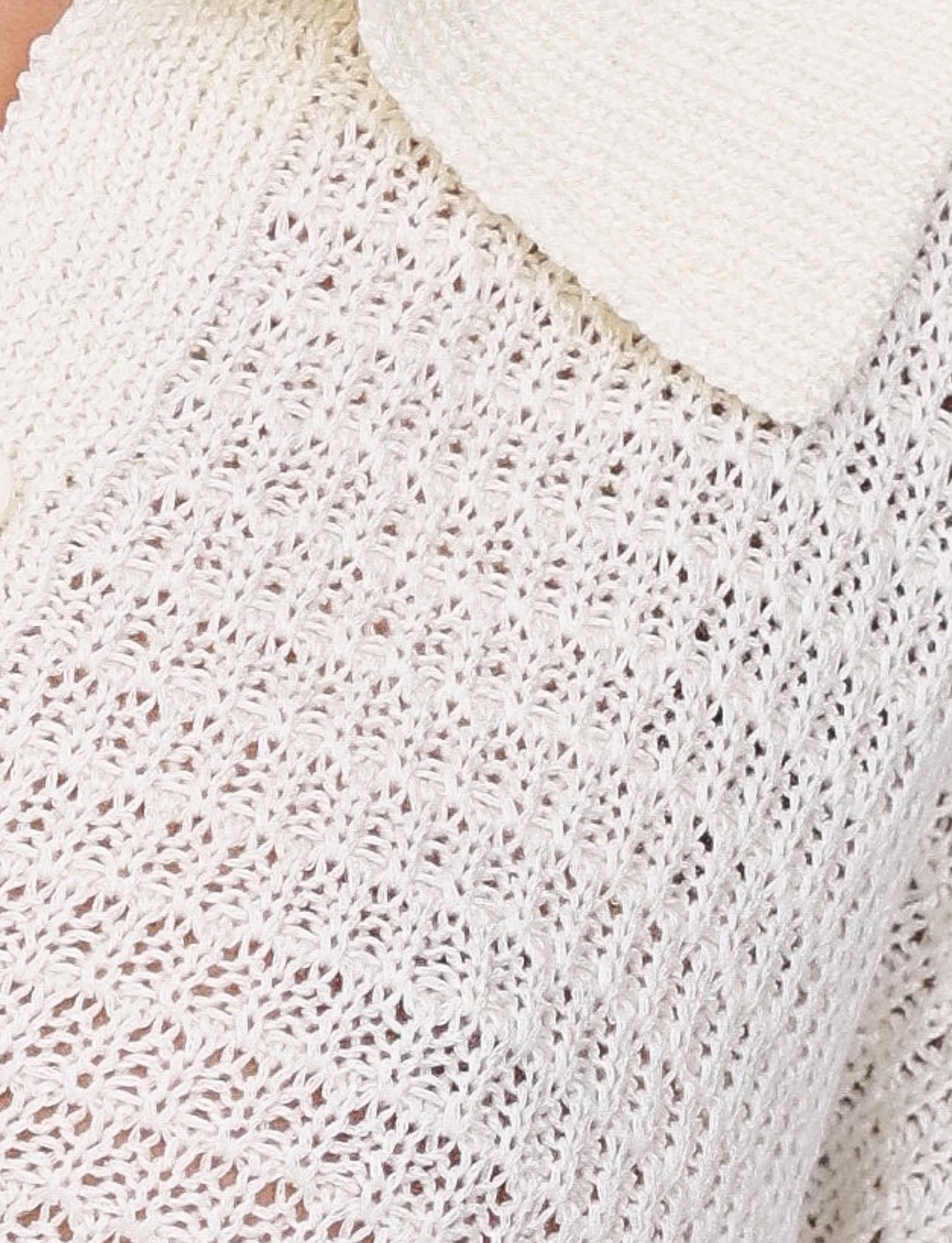 Close-up of the TIGERMIST JANAI TOP in white, showcasing its intricate, textured pattern. The image captures part of a V-neckline and collar, adding to the garment's overall detail and design.