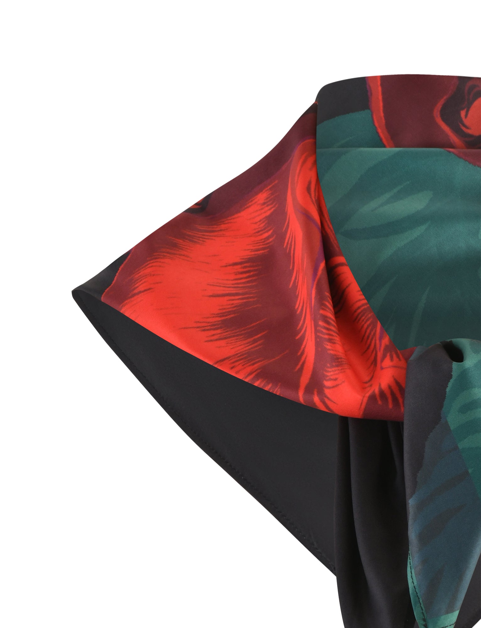 Here's a close-up image of the JOZIE SCARF from TIGERMIST. This colorful silk scarf showcases bold patterns in vibrant red, green, and black shades. The fabric exhibits a smooth and shiny texture, with a prominently displayed corner highlighting its intricate details.