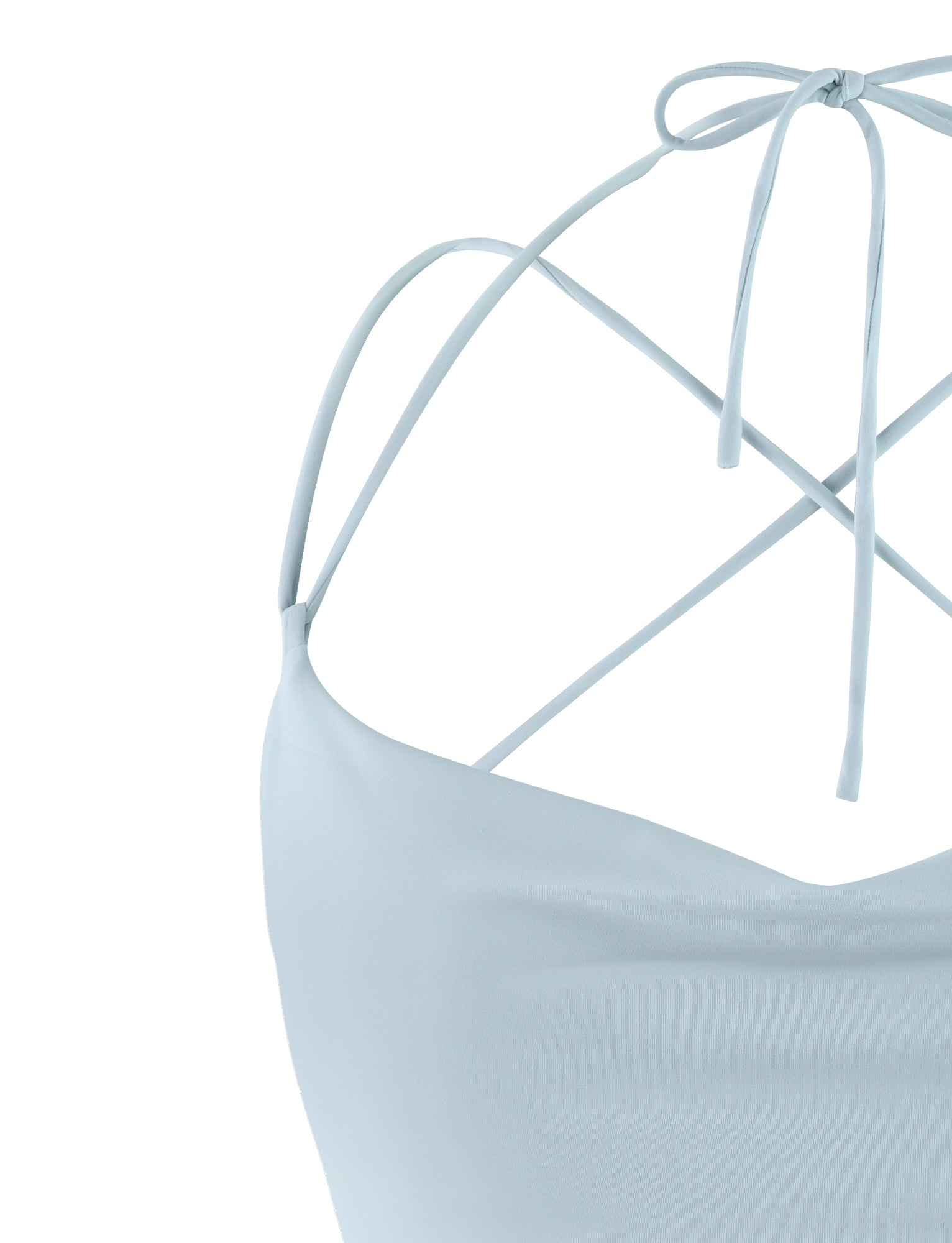Close-up of the pastel blue ZAIDA TOP from TIGERMIST, showcasing its halter-neck design with thin straps that cross in the back and tie at the neck in a bow. The garment exhibits a smooth, minimalist aesthetic. The photo focuses on the shoulder and neckline area, emphasizing the intricate strap arrangement.