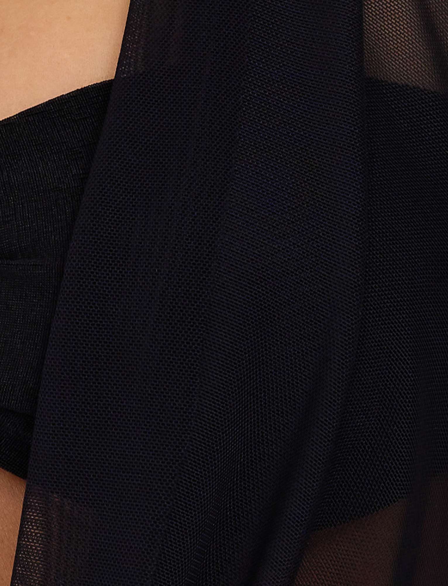 Close-up of the MAKENA TWO-PIECE TOP in black by TIGERMIST, featuring sheer mesh fabric draped over skin with semi-transparent, textured layers creating subtle shadows.