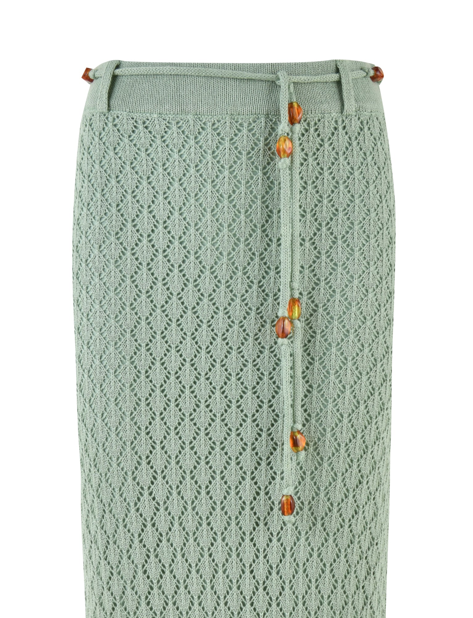 The COLLINA SKIRT - GREEN by TIGERMIST is a mint green, high-waisted maxi length crochet skirt with a diamond pattern and features a tie belt adorned with amber beads.