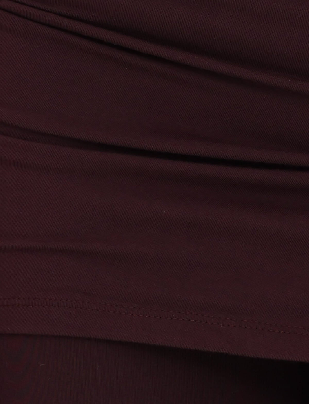 A detailed view of the LEILANI PANT - BROWN : CHOCOLATE from TIGERMIST highlights the visible stitching and folds, indicative of apparel. The fabric has a smooth texture with a bit of elasticity, suggesting it's made from high-stretch material ideal for comfort and fit.