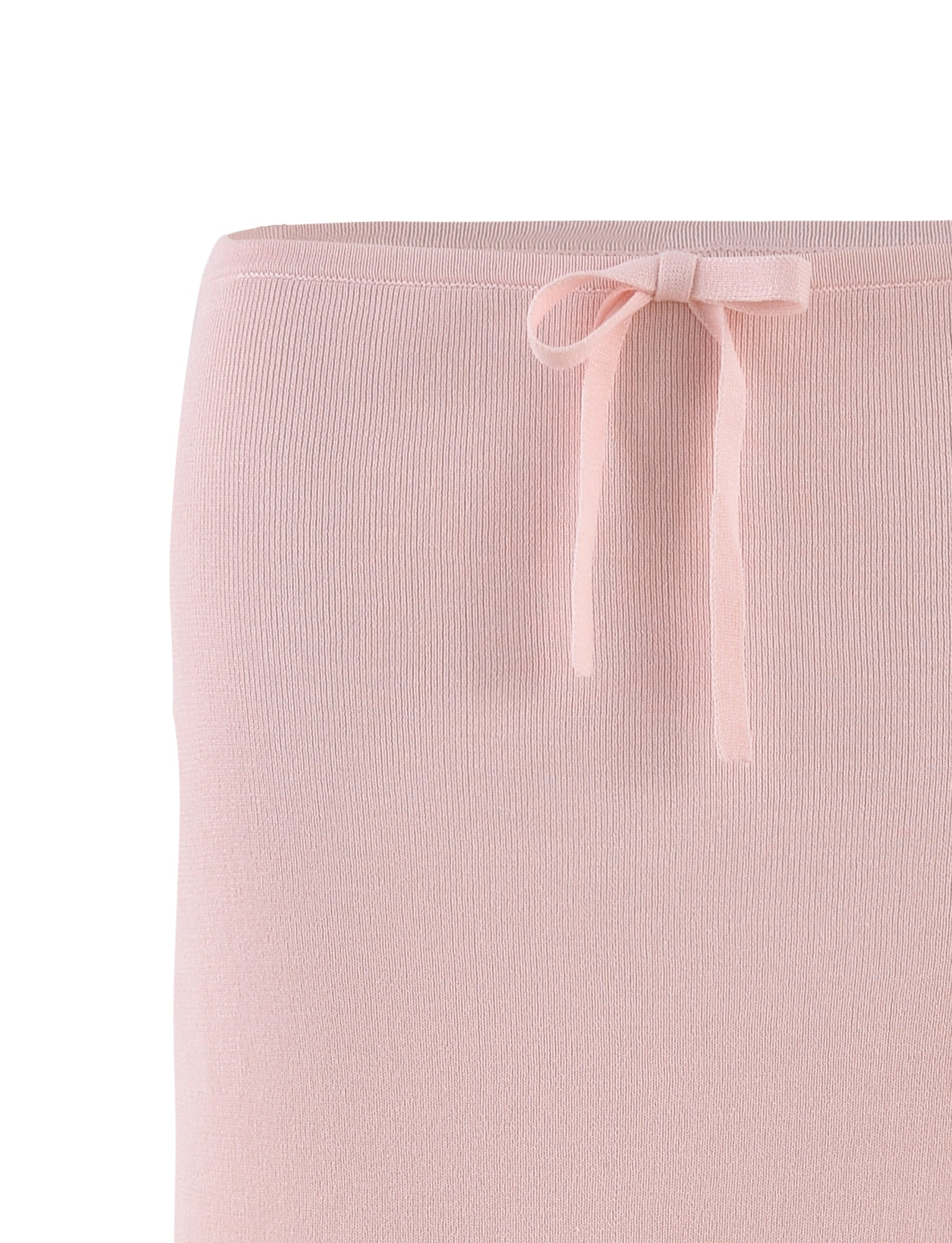 A close-up of the LILYANNA SKIRT in a lovely baby pink hue from TIGERMIST, highlighting its simple waistline design adorned with a same-material decorative bow. This knit midi skirt offers a soft, smooth texture with fine ribbing, ideal for fans of relaxed fit fashion.