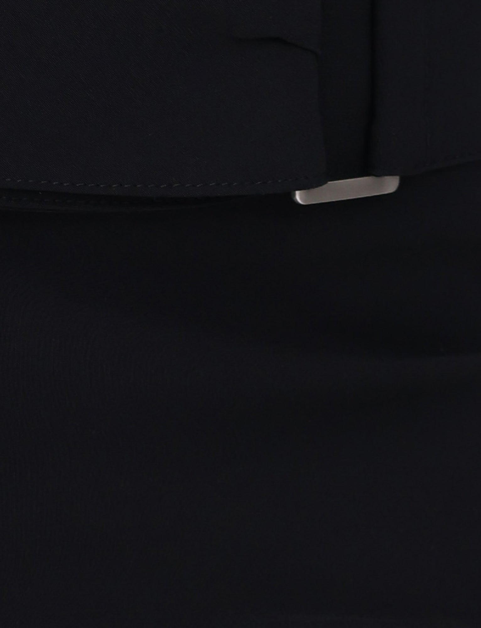 Close-up of the TIGERMIST VESPER PANT in black, featuring a partially visible silver rectangular buckle or clasp. The smooth and slightly textured fabric highlights a fitted silhouette.