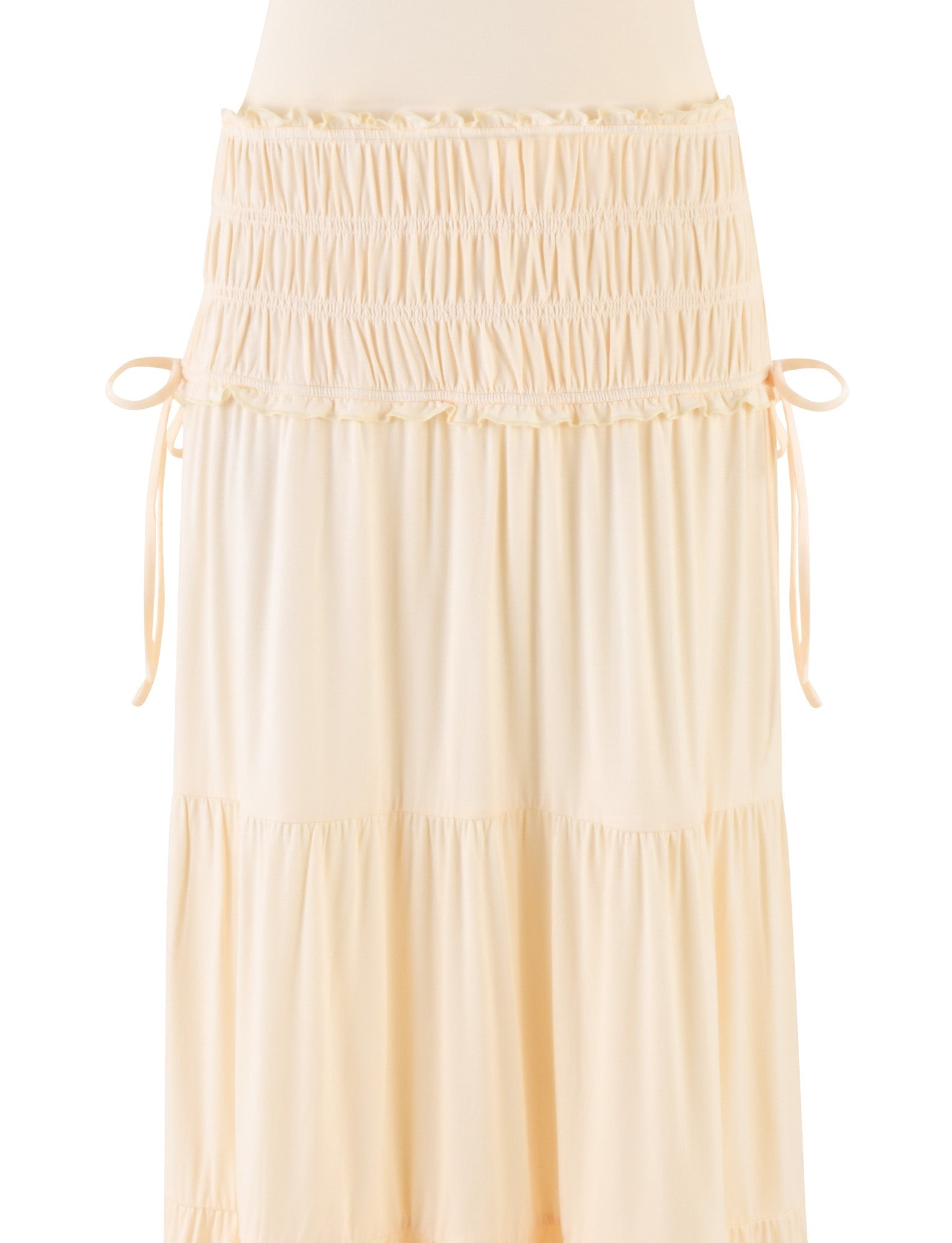 The DENALI HALTER DRESS - NEUTRAL: BONE by TIGERMIST is a cream-colored full skirt dress with tiers, a ruched waistband, and adjustable side ties, shown against a white background.