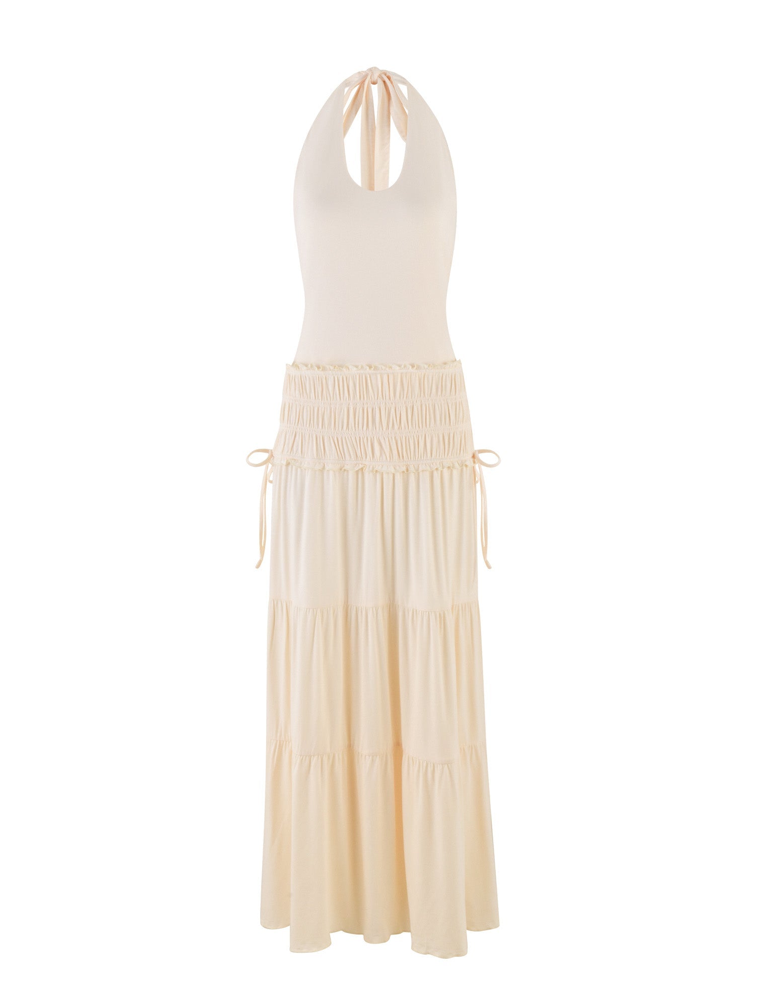 The TIGERMIST DENALI HALTER DRESS in Bone is a cream-colored maxi with a fitted sleeveless bodice, keyhole neckline, tiered skirt, adjustable side waist ties, and a soft, flowing silhouette in buttery jersey.