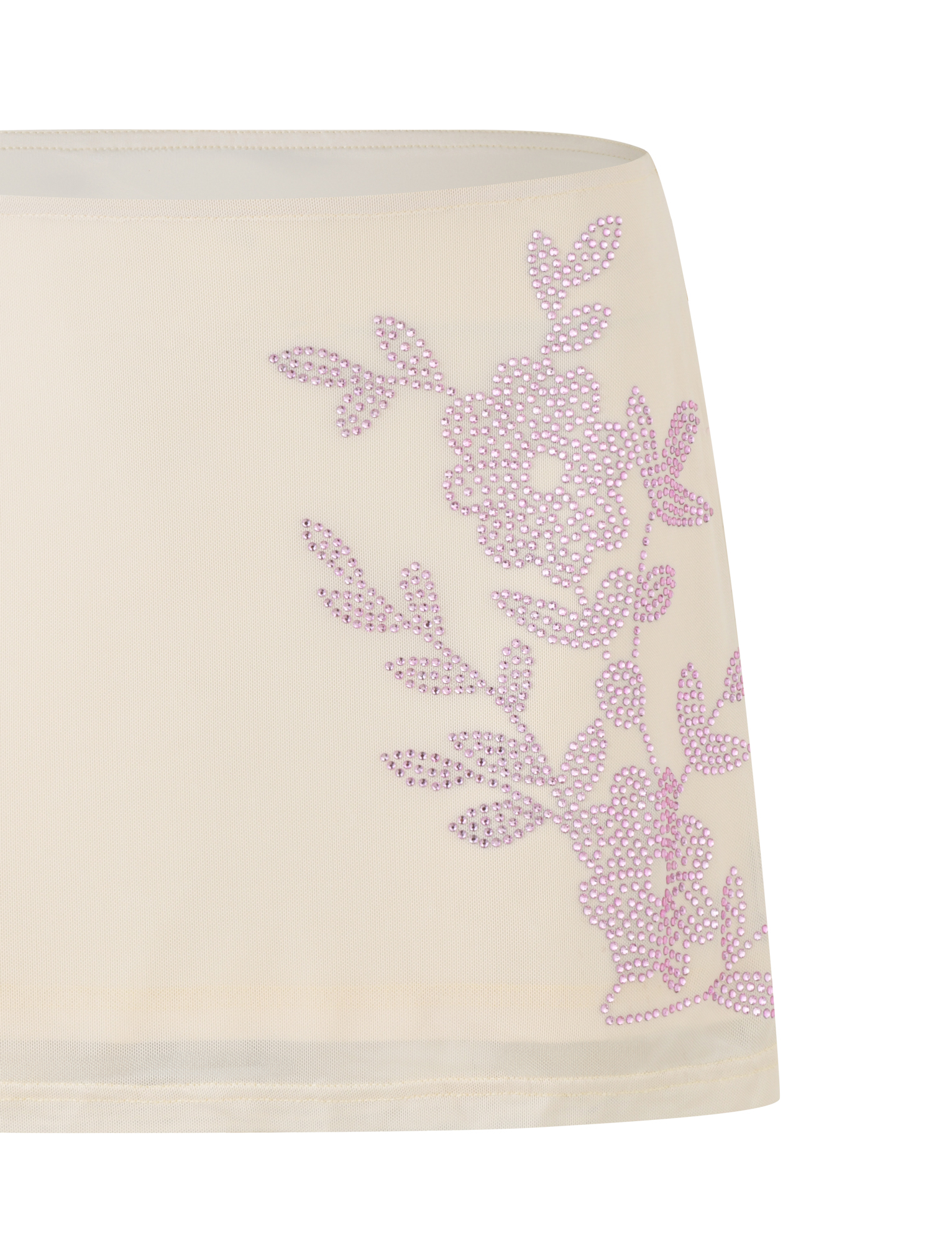 The TIGERMIST OCTAVIA MINI SKIRT in cream is a sheer, neutral mini skirt with pink rhinestone flower and leaf embellishments on one side.